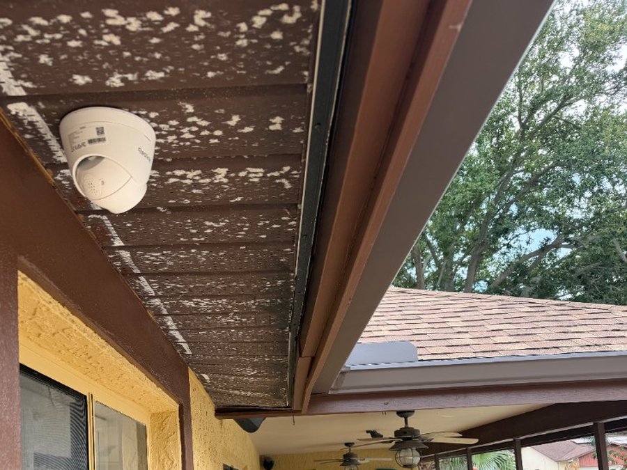 Outdoor security camera mounted under patio soffit with concealed wiring