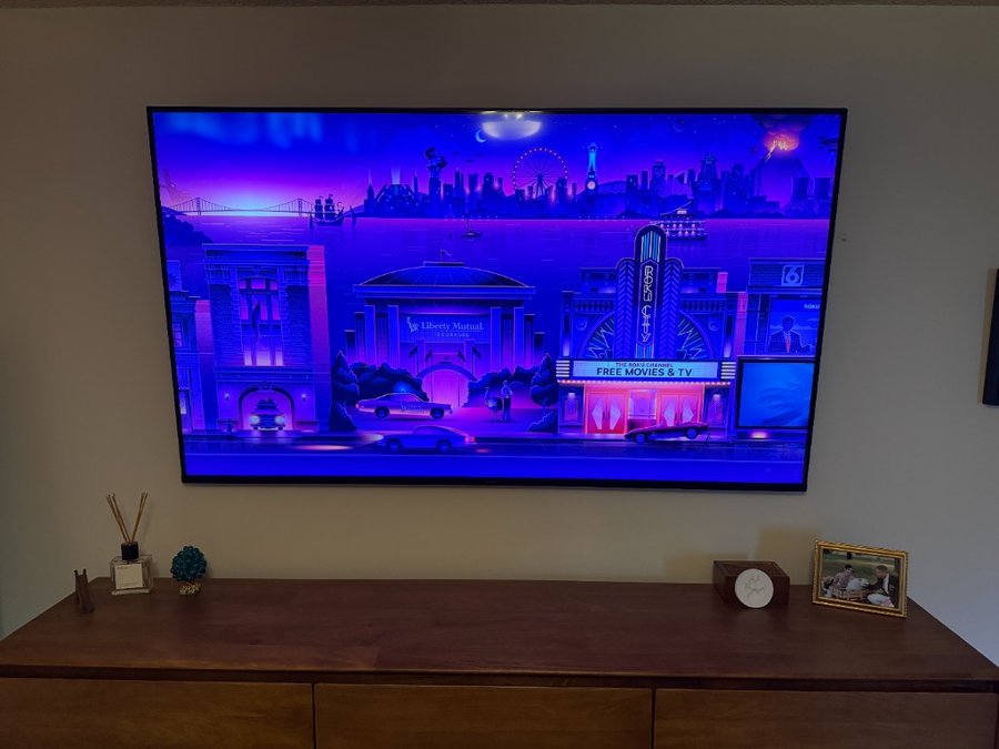 75 inch Roku TV wall mounted in a bedroom with no visible wires